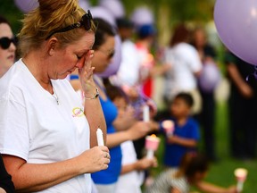 Nicole Callaghan, operations manager at Alpha House, joins co-workers and friends of Christine Archibald at a vigil Sunday at Prince’s Island Park.