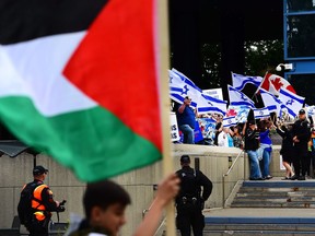 A Palestinian flag flys as a counter-protest takes place across the park. The al Quds pro Palestine rally drew hundreds in support as well as a crowd of counter-protesters at City Hall in Calgary, Alta., on June 23, 2017. Ryan McLeod/Postmedia Network
Ryan McLeod, Ryan McLeod/Postmedia Network