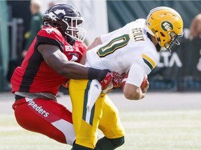 Calgary Stampeders Micah Johnson (4) sacks Edmonton Eskimos quarterback Mike Reilly (0) during first half CFL pre-season action in Edmonton on June 11, 2017.