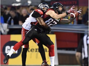 Calgary Stampeders' Joe Burnett (24) prevents Ottawa Redblacks' Greg Ellingson from making a catch during first period CFL action in Ottawa on Friday, June 23, 2017.