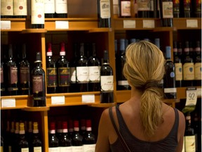 A customer browses wine displayed for sale.