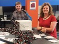 Bryan Chapman, Jason Caldwell and Shauna Caldwell print signs and assemble lanyards for the hundreds of volunteers who will help run Hope 150, a free, family friendly event being held Friday.