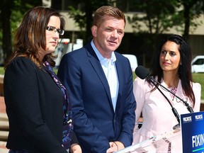 Wildrose Leader Brian Jean, joined by justice critic Angela Pitt (left) and status of women critic Leela Aheer, at a press conference at McDougall Centre in Calgary Friday.
