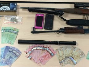 Drugs, guns and cash were seized in a June 22 raid of a suspected drug house in Applewood.