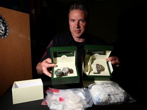 Staff Sgt. Mark Hatchette, with the Calgary Police Service Investigative Operations Section, displays some of the watches and drugs seized during a press conference in Calgary on Thursday, June 15, 2017.