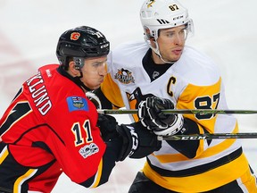 Calgary Flames Mikael Backlund battles against Sidney Crosby of the Pittsburgh Penguins during NHL hockey in Calgary, Alta., on Monday, March 13, 2017.