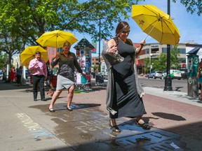 From left; Bruce Furlong and Chris Thompson-Hunter with the City of Calgary and Annie MacInnis with the Kensington BRZ try out some rain art hopscotch in Kensington on Tuesday, June 6, 2017. There are forty hopscotch sidewalk rain art pieces in Kensington that only are visible when they are wet. The event was the City of Calgarys kick-off of its age-friendly business initiative, part of Seniors Week to help promote a comfortable and accessible environment for an aging population and customer base. Gavin Young/Postmedia Network