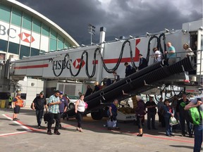 Passengers at Calgary International Airport file onto the tarmac after reports of an active shooter prompted an evacuation of the busy air terminal. City police confirmed the call, along with reports of a nearby car fire, were a hoax.  Photo courtesy Adrian Jean/Twitter