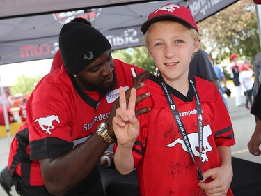 The Calgary Stampeders' Ja’Gared Davis signs autographs outside McMahon Stadium before the team's home opener against the Ottawa Redblacks on June 29, 2017.  Gavin Young/Postmedia Network