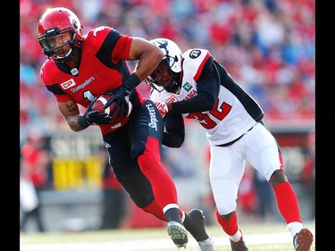 Calgary Stampeders Lemar Durant carries the ball as Nicholas Taylor of the Ottawa Redblacks moves in to tackle him during CFL football in Calgary. AL CHAREST/POSTMEDIA