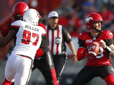 Calgary Stampeders quarterback Bo Levi Mitchell looks to throw the ball while under pressure from Steve Miller of the Ottawa Redblacks during CFL football in Calgary. AL CHAREST/POSTMEDIA