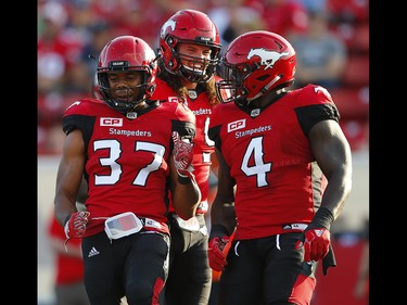 Calgary Stampeders Maleki Harris, Alex Singleton and Micah Johnson celebrate after brings down  Trevor Harris of the Ottawa Redblacks during CFL football in Calgary. AL CHAREST/POSTMEDIA