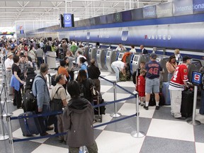 Passengers wait in lines to check in at the United Airlines terminal at O'Hare International Airport in Chicago.