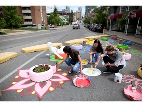 Western Canada High School students Alley Prete, 17, left, Alex Davies, 17 and Sampson McFerrin, 16, decorate Royal Avenue with artwork on Fridat June 9, 2017.