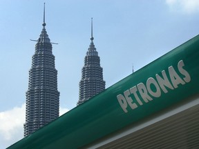 A sign for a Petroliam Nasional Bhd. (Petronas) gas station stands near the Petronas KLCC Twin Towers in Kuala Lumpur, Malaysia, on Saturday, Nov. 7, 2009. Oil companies seeking to bid in three new projects as minority partners in Venezuela's Orinoco Belt are forming at least five teams, Reuters reported, citing people it didn't name. Photographer: Goh Seng Chong/Bloomberg
Goh Seng Chong, Bloomberg