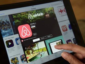 (FILES) This file photo taken on April 28, 2016 shows a woman browsing the site of US home sharing giant Airbnb on a tablet in Berlin on April 28, 2016. Barcelona city hall said on November 24, 2016 it would fine home rental websites Airbnb and rival HomeAway 600,000 euros ($635,000) each for marketing lodgings that lacked permits to host tourists. The fine comes as the popular seaside resort struggles with a rising tide of tourism that has exasperated locals, threatening to drive out poorer residents and spoil the charm of Spain's second-largest city.  / AFP PHOTO / John MACDOUGALLJOHN MACDOUGALL/AFP/Getty Images