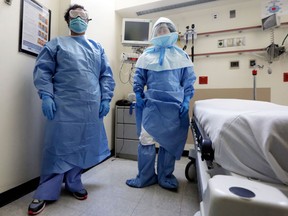 Bellevue Hospital nurse Belkys Fortune, left, and Teressa Celia, Associate Director of Infection Prevention and Control, pose in protective suits in an isolation room, in the Emergency Room of the hospital, during a demonstration of procedures for possible Ebola patients, Wednesday, Oct. 8, 2014. The U.S. government plans to begin taking the temperatures of travelers from West Africa arriving at five U.S. airports, including the New York area&#039;s JFK International and Newark Liberty