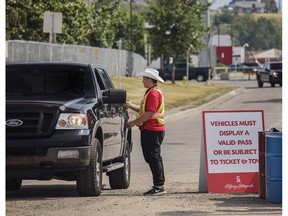 A parking attendant checks the pass of a vehicle entering the 11th Avenue S.E. lot on Wednesday, July 12.