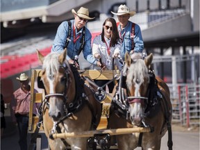 Postmedia reporter Alanna Smith takes a turn at the reins with two of the Calgary Stampede's draft horses. Tom Christensen, Vice Chair of Draft Horse Town, is at her left, with Dean Sundquist of Draft Horse Town behind. KERIANNE SPROULE/POSTMEDIA

Postmedia Calgary Stampede2017
Kerianne Sproule