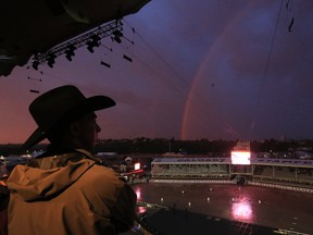 Spectators watch a rainbow over the empty infield after an intense thunderstorm swept through Calgary and the Stampede grounds cancelling the GMC Rangeland Derby after heat 6 on Monday evening July 10, 2017.