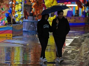 Environment Canada says there's a thunderstorm risk in the evening, bringing between five to 10 millimetres of rain to the city. This file photos shows a rainy Calgary Stampede midway on Monday evening July 10, 2017