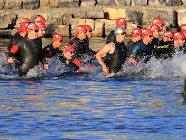 Triathletes race into the water at Auburn Lake during the Calgary Ironman 70.3 race on Sunday July 23, 2017.