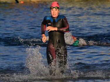 The first place pro woman races out of the water of Auburn Lake during the Calgary Ironman 70.3 race on Sunday July 23, 2017.