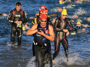 Triathletes surge out of Auburn Lake and head to the bike transition during the Calgary Ironman 70.3 race on Sunday July 23, 2017.