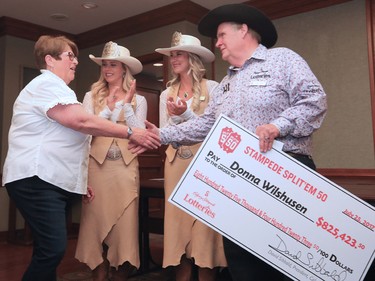 2017 Stampede Split’Em 50 Prize winner, Donna Wilshusen, shakes hands wth Stampede Lotteries Chairman Lynn Grant at the Stampede Lotteries reception with Stampede Queen Meagan Peters, and Princess Lizzie Ryman at Stampede Park on Tuesday afternoon July 25, 2017. $825, 232 was the payout in the 50/50 lottery.