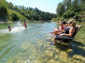 The Babin sisters have fun cooling off in the Elbow River while family watches near Sandy Beach on a hot Thursday afternoon July 27, 2017.