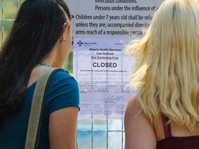 Visitors read the closed sign at Prairie Winds Park wading pool on Monday July 31, 2017. The park was closed after some users had cut their feet in the area. Gavin Young/Postmedia