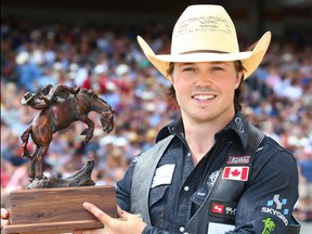 Calgary cowboy Connor Hamilton poses for a photo with his trophy bronze after winner the 2017 novice bareback competition at the Calgary Stampede rodeo.