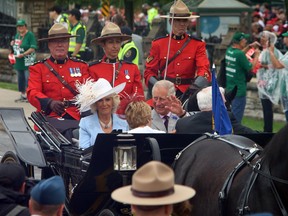 Camilla Duchess of Cornwall and Prince Charles wave to the crowd as they ride in a carriage during Canada 150 celebrations in Ottawa on Saturday, July 1, 2017. THE CANADIAN PRESS/ Fred Chartrand
