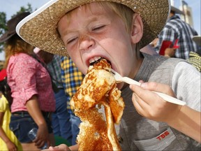 Paxton Johnson,6, digs in as CF Chinook Centre hosted its 57th Annual Stampede Breakfast in Calgary with all proceeds raised through the sponsorship of the event to benefit the Alberta Childrens Hospital Foundation on Saturday July 8, 2017. DARREN MAKOWICHUK/Postmedia Network