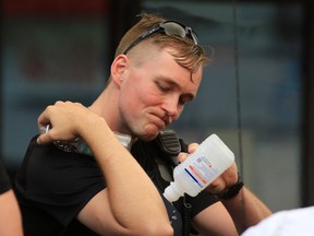 One of two police officers who were pepper sprayed washes off after an incident in Calgary's beltline on Wednesday evening July 26, 2017. Gavin Young/Postmedia