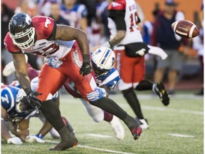 Stampeders' Jerome Messam drops the ball as he is tackled by the Montreal Alouettes defence in Montreal on Friday, July 14.