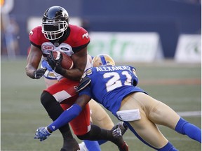 Calgary Stampeders Jerome Messam (33) dodges a tackle by Winnipeg Blue Bombers' Brandon Alexander (21) during the first half of CFL action in Winnipeg Friday, July 7, 2017.