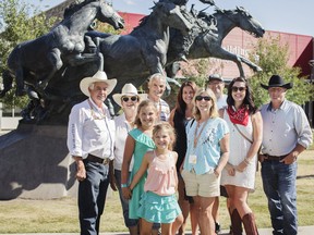 Mark and Carol Pollard and their family welcome tourists into their lives during the Stampede. For 30 years, the couple have been sharing extra chairs along the parade route, bringing tourists to Stampede breakfasts and even inviting some to stay in their home for free. The Pollards and their family spent Thursday at the Stampede with their newfound friends Ian and Denise Bryant from New Zealand. Pictured, from left, is Mark and Carol Pollard, Ian Bryant, Melissa Pollard, Denise Bryant, Kris Kovatch, Jessica and Curtis Evans and grandchildren Scarlette and Lyra Kovatch (front). KERIANNE SPROULE/POSTMEDIA