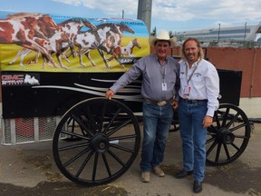 Chuckwagon driver Gary Gorst (left) and artist Paul Van Ginkel pose next to the originally painted canvass on Gorst's wagon at the Calgary Stampede. Supplied photo