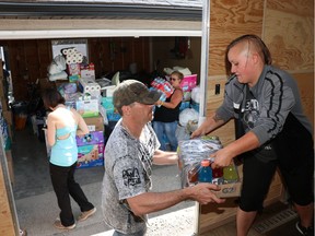 Katlyn Anderson, right, loads supplies for people displaced by the B.C. fires in Marda Loop in Calgary on Thursday, July 20, 2017. Anderson was evacuated from Fort McMurray last year and was compelled to help out with the fires in B.C. The donations for people displaced by the fire using the Facebook group Calgary Helps YMM And Now BC. The donations were collected over five days and will be delivered to Kamloops B.C. The donations were transported and loaded by the group the Three Percenters. (Photo by Chelsea Kemp/Airdrie Echo) ORG XMIT: CK_BC_Fires_CK

Postmedia Calgary
Chelsea Kemp