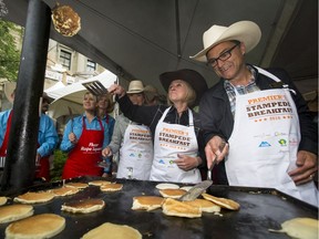 Premier Rachel Notley flips a pancake with Joe Ceci at her annual pancake breakfast last year. The premier's annual Stampede Breakfast goes Monday, July 10.