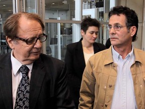 David Milgaard, accompanied by lawyer Hersh Wolch, speaks briefly with reporters as he leaves the courthouse in Calgary, Alberta, on November 14, 2011. He had been charged with assault but the charges were withdrawn and he was released on a peace bond.