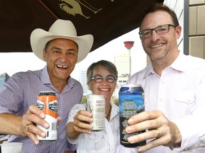 L-R, Joe Ceci, president of Treasury Board and Minister of Finance, toasts with Calgary councillor Druh Farrell and Terry Rock, executive director of the Alberta Small Brewers Association, after announcing a new policy to make it easier for licensed venues to have greater control over the size of their patios and fewer restrictions on how they are built at the King Eddy in Calgary on Sunday July 9, 2017. DARREN MAKOWICHUK/Postmedia Network