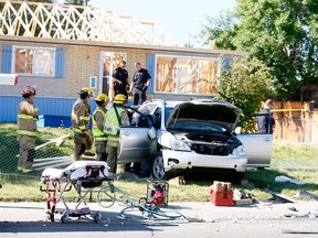 Police tend to the driver of an SUV which lost control and crashed in the 5400 block of 14th Avenue S.E. on Wednesday.