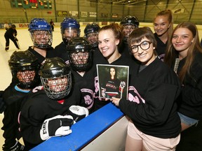 L-R, Friends Daina Hughes and Kelsey Nelson along with participants hold up a picture of Meghan Bombford who was killed on October 18th, 2016 in a drunk driving accident on McKnight BLVD. have organized a 24 hour ringette game held from 12:45pm Saturday continuously until 12:45pm Sunday and a silent auction at the North East Sportsplex in Calgary to raise money to create a scholarship in her name on on Saturday July 8, 2017. DARREN MAKOWICHUK/Postmedia Network