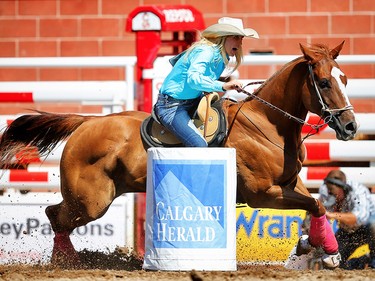 Tiany Schuster of Krum, Texas breaks the arena record for fastest barrel race at 16.99 seconds at the Calgary Stampede rodeo. AL CHAREST/POSTMEDIA