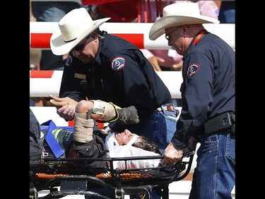 North Carolina bull rider JB Mauney is wheeled out of the infield after injuring him self during his winning ride on Cowahbunga at the Calgary Stampede rodeo. AL CHAREST/POSTMEDIA