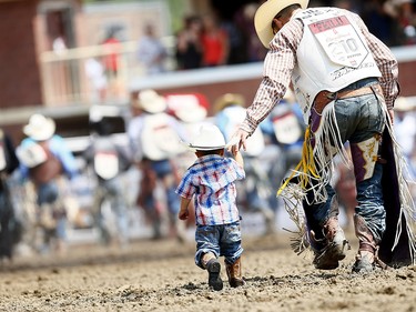 Cowboys bring out their kids during the grand entry on day 6 of the 2017 Calgary Stampede rodeo on  Wednesday July 12, 2017. DARREN MAKOWICHUK/Postmedia Network