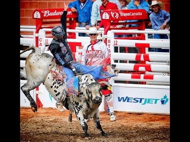 Prince Albert, Saskatchewan cowboy Tanner Byrne rides a bull called All Fired Up to a score of 84 points at the Calgary Stampede rodeo. AL CHAREST/POSTMEDIA