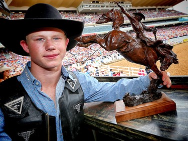 Dawson Hay of Wildwood, Alberta poses for a photo with his trophy bronze after winner the 2017 novice saddle bronc competition at the Calgary Stampede rodeo. AL CHAREST/POSTMEDIA